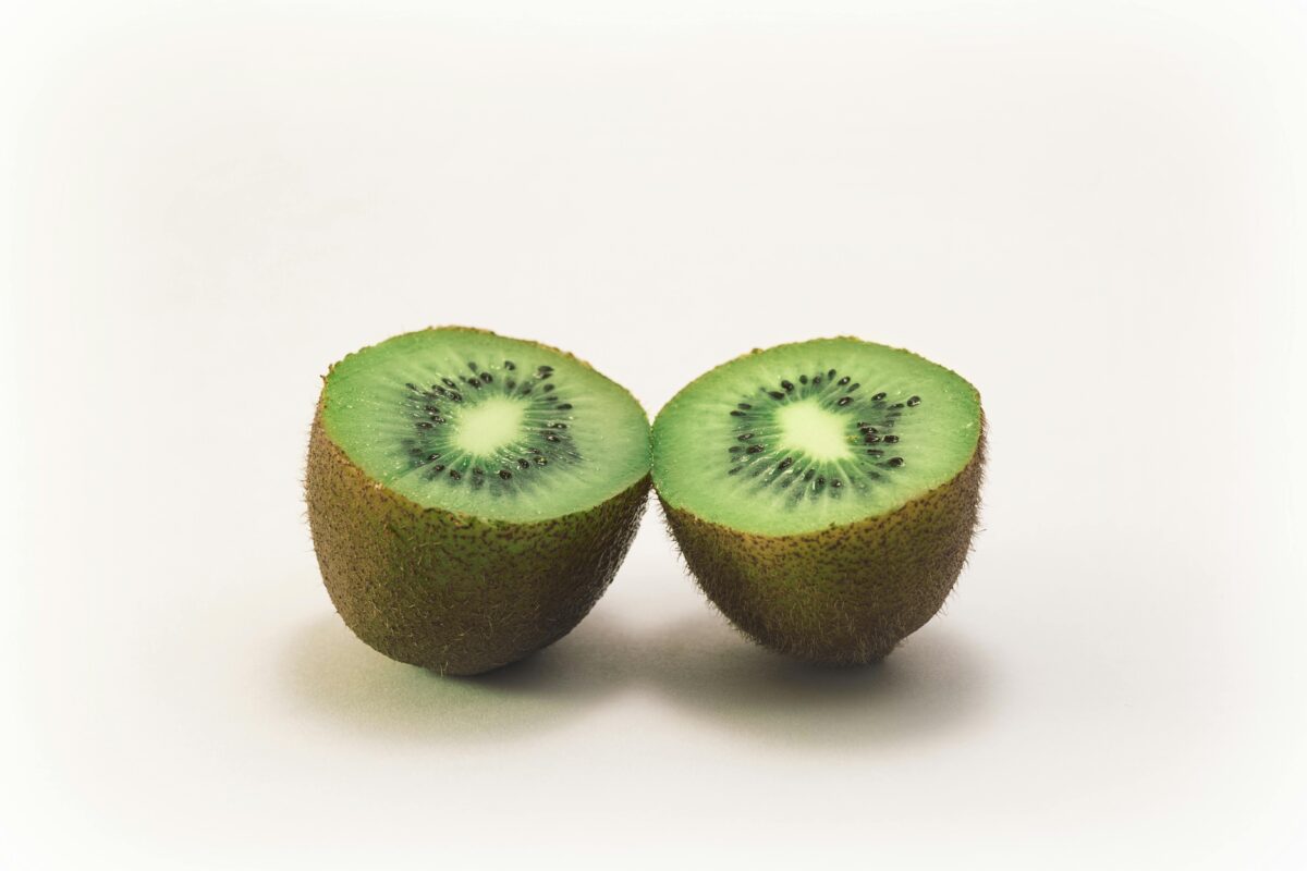 Close-up of two fresh kiwi halves displaying vibrant green color and texture, highlighting freshness and nutrition.