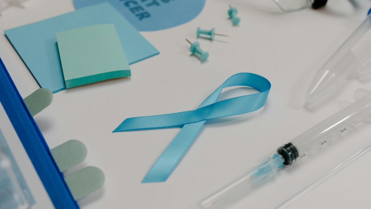 Blue ribbon with medical supplies symbolizes healthcare awareness and cancer support.
