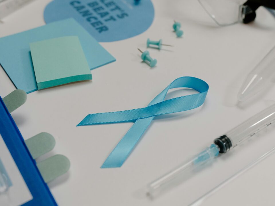 Blue ribbon with medical supplies symbolizes healthcare awareness and cancer support.
